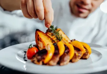 Vaporisation d’un parfum culinaire Lise Baccara sur un plat salé aux herbes provençales